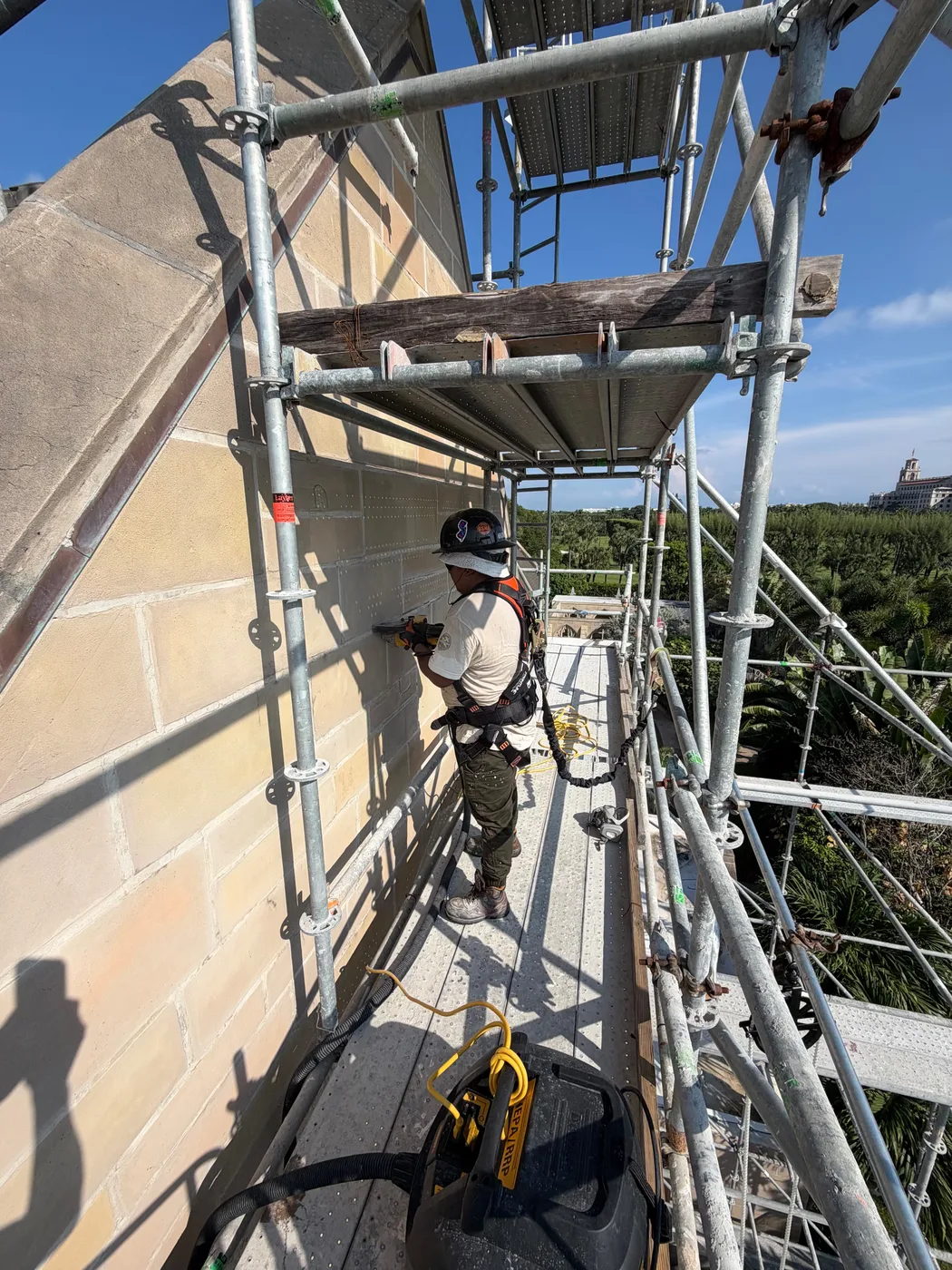 A mason cutting out damaged stone on the scaffolding at the Church of Bethesda-by-the-Sea in Palm Beach, Florida